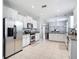 Kitchen with stainless steel refrigerator, oven, and microwave oven, white cabinets, and tile flooring at 3512 Gerrads Cross Ct, Land O Lakes, FL 34638