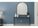 Modern entryway with a minimalist console table, arched mirror, and blue accent wall at 36095 Risa Michele St, Zephyrhills, FL 33541