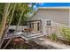 Charming home exterior featuring a covered deck with outdoor dining, lush landscaping, and a well-maintained yard at 3620 W San Pedro St, Tampa, FL 33629
