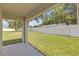Covered patio with tile flooring and views of a large, green fenced-in backyard at 36628 Spanish Rose Dr, Dade City, FL 33525