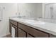 Bathroom featuring double sinks with dark wood cabinets and elegant faucets at 36628 Spanish Rose Dr, Dade City, FL 33525