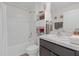 Bright bathroom featuring a tub and shower combination, white vanity, and ample storage shelves at 36628 Spanish Rose Dr, Dade City, FL 33525