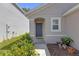 Charming home entrance featuring a gray front door and well-manicured landscaping at 36628 Spanish Rose Dr, Dade City, FL 33525