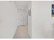 Well-lit hallway showcasing neutral tile flooring and clean, white walls leading to various rooms at 36628 Spanish Rose Dr, Dade City, FL 33525