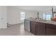 Kitchen featuring stainless steel appliances, dark wood cabinets, granite countertops and tile flooring at 36628 Spanish Rose Dr, Dade City, FL 33525