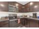 Kitchen featuring stainless steel appliances, dark wood cabinets, granite countertops and tile flooring at 36628 Spanish Rose Dr, Dade City, FL 33525