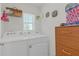 Functional laundry area equipped with a washer, dryer, storage, and a window providing natural light at 36628 Spanish Rose Dr, Dade City, FL 33525