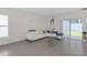 Bright living room features a white leather sectional sofa, modern decor and sliding glass doors to a backyard at 36628 Spanish Rose Dr, Dade City, FL 33525