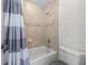 Well-lit bathroom featuring tiled walls, a shower-tub combination, and modern fixtures at 4515 W Leona St, Tampa, FL 33629