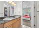 Bright bathroom leading to a bedroom with double sinks and granite countertop at 4515 W Leona St, Tampa, FL 33629