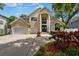 Stately two-story home featuring a large double door entry, three car garage, and manicured landscaping in daylight at 4515 W Leona St, Tampa, FL 33629