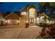 Stately two-story home featuring a large double door entry, three car garage, and manicured landscaping at twilight at 4515 W Leona St, Tampa, FL 33629