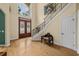 Grand foyer featuring wood floors, a staircase with black railings, and a decorative front door at 4515 W Leona St, Tampa, FL 33629