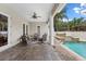 Inviting covered patio with comfortable seating, ceiling fan, and views of the pool and water feature at 4515 W Leona St, Tampa, FL 33629