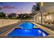 A sparkling in-ground pool with lights is surrounded by a brick paver patio and a covered living area at 4515 W Leona St, Tampa, FL 33629