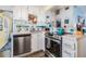 White kitchen with stainless steel appliances, eye-catching backsplash, and updated countertops at 526 5Th N Ave, Safety Harbor, FL 34695