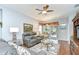 Comfortable living room with leather reclining sofa, ceiling fan, and sliding glass doors to outdoor patio at 6030 Sandhill Ridge Dr, Lithia, FL 33547