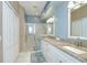 Bright bathroom with double sinks, granite counters, and large glass-enclosed shower with a neutral palette at 6030 Sandhill Ridge Dr, Lithia, FL 33547