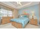 Serene main bedroom featuring a tray ceiling, large window, and wood furniture with an accent wall at 6030 Sandhill Ridge Dr, Lithia, FL 33547