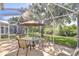 Covered patio with outdoor dining set overlooks verdant scenery and a serene creek at 6030 Sandhill Ridge Dr, Lithia, FL 33547