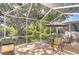 Relaxing screened patio with outdoor seating, a grill, and views of a lush green space at 6030 Sandhill Ridge Dr, Lithia, FL 33547