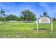 FishHawk Skate Park sign in a grassy field with skate ramps and a large shade tree at 6030 Sandhill Ridge Dr, Lithia, FL 33547