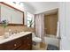 Bathroom with a wooden vanity, marble countertop, and shower-tub combo at 6705 Ranger Dr, Tampa, FL 33615