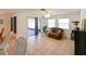 Bright living room featuring neutral tile floors, ceiling fan, and sliding door access to a screened lanai at 6705 Ranger Dr, Tampa, FL 33615
