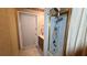 Bathroom featuring a shower over tub with glass doors, tile floors and a single sink with oak cabinetry at 7111 Oregon Chickadee Rd, Weeki Wachee, FL 34613
