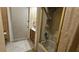Bathroom featuring a shower over tub with glass doors, tile floors and a single sink with oak cabinetry at 7111 Oregon Chickadee Rd, Weeki Wachee, FL 34613