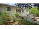 Charming home exterior with a staircase leading to the entrance, surrounded by lush greenery at 7111 Oregon Chickadee Rd, Weeki Wachee, FL 34613