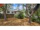 Exterior view of a two-story house with mature trees and a brown lawn at 7111 Oregon Chickadee Rd, Weeki Wachee, FL 34613