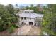 Unique two-story home with a metal roof and a two-car garage surrounded by lush greenery at 7111 Oregon Chickadee Rd, Weeki Wachee, FL 34613