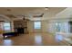 Spacious living room featuring hardwood floors, a stone fireplace, ceiling fans and sliding glass doors to the outside at 7111 Oregon Chickadee Rd, Weeki Wachee, FL 34613