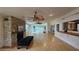 Spacious living room featuring hardwood floors, a stone fireplace, ceiling fans and sliding glass doors to the outside at 7111 Oregon Chickadee Rd, Weeki Wachee, FL 34613