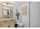 Well-lit bathroom with vanity, decorative mirror, elegant floral arrangements, and a convenient storage closet at 7520 Sunshine Skyway S Ln # 113, St Petersburg, FL 33711