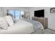 Cozy bedroom featuring balcony access with lovely ocean views, a large TV, and neutral tones at 7520 Sunshine Skyway S Ln # 113, St Petersburg, FL 33711