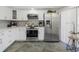 Bright kitchen featuring white cabinets, modern appliances, and stone tile flooring at 7520 Sunshine Skyway S Ln # 113, St Petersburg, FL 33711