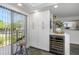 Bright kitchen area with a wine fridge, storage cabinets, counter space and a leafy view at 7520 Sunshine Skyway S Ln # 113, St Petersburg, FL 33711