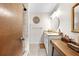 Bright bathroom features a vanity with decor, shower, a towel rack, and a large mirror with gold trim at 8083 Bayhaven Dr, Seminole, FL 33776