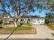 Charming home featuring a well-manicured lawn, mature trees, and a spacious driveway leading to a two-car garage at 8083 Bayhaven Dr, Seminole, FL 33776