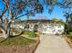 Charming single-story home features a two-car garage, lush landscaping, and a mature shade tree at 8083 Bayhaven Dr, Seminole, FL 33776