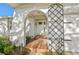 Close up of an arched front porch entry and tiled walkway, framed by lush greenery at 8083 Bayhaven Dr, Seminole, FL 33776