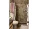 Tiled walk-in shower bathroom with a white toilet, towel rack, and toiletries shelf at 8105 Sheldon Shores Dr, Tampa, FL 33615
