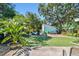 Landscaped backyard with artificial grass, patio, fire pit area, shed and tropical foliage at 905 8Th Sw Ave, Largo, FL 33770