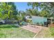 Enjoy the outdoor space with a brick patio, table, chairs, well-manicured lawn, and tropical plants at 905 8Th Sw Ave, Largo, FL 33770