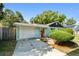 Charming home featuring a well-kept lawn, driveway, and a red front door that adds a pop of color to the facade at 905 8Th Sw Ave, Largo, FL 33770