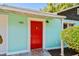 View of the home's inviting red front door, set against a turquoise exterior, creating a vibrant welcome at 905 8Th Sw Ave, Largo, FL 33770