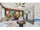 Cozy living room featuring wood walls, a unique gear-shaped coffee table, and an abundance of natural light at 905 8Th Sw Ave, Largo, FL 33770