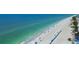 Breathtaking aerial view of a beautiful beach with clear turquoise water and rows of colorful umbrellas at 10216 Regal Dr # 310, Largo, FL 33774